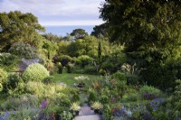 View from a terrace over a sloping garden towards the sea in July
