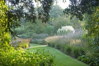 Perennial borders edge the ' Long Walk' at Knoll Gardens in Dorset