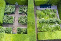 Garden rooms formed by mature clipped hedges of Taxus baccata containing two small formal gardens. June. Summer. Image taken with drone. 