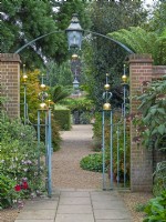 Entrance Court at East Ruston Old Vicarage Gardens, Norfolk. 
 Decorative iron work gateway, walls and paths Autumn  September