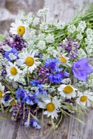 Wildflower bouquet containing daisies, wild carrots, harebells, alliums and cornflowers.