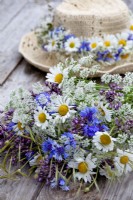Wildflower bouquet containing daisies, alliums and cornflowers.