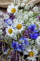 Wildflower bouquet containing daisies, alliums and cornflowers.