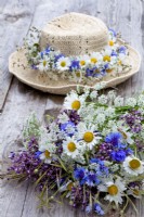 Wildflower bouquet containing daisies, wild carrots, alliums and cornflowers.