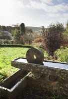 Stone water troughs on the terrace with views of the garden and countryside.