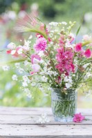 Bouquet of flowers containing Gypsophila elegans 'Covent Garden', Centaurea cyanus - pink, Delphinium 'Salmon Spire', Hordeum jubatum and Lathyrus 'Painted Lady' - Sweet Peas in glass vase