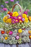 Floral arrangement of dried flowers and seedheads including strawflowers, sedum and teasel.