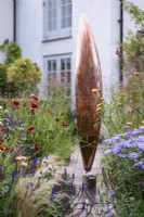 September garden with Seed Pod by Ted Edley surrounded by grasses and herbaceous perennials