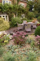 Sunken seating area surrounded by raised borders of sedums and euphorbias in September