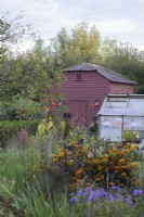 Painted granary surrounded by lush planting in September