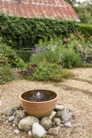 Bubblling water feature in a September garden