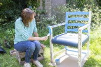 Woman painting the chair blue