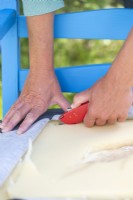 Woman using stanley knife to cut out the foam from the cushion