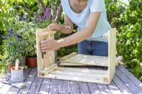 Woman assembling wooden crate