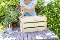 Woman assembling wooden crate