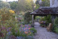 Mixed tulips and forget-me-nots in informal spring borders, at Gravetye Manor, Sussex