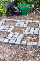 Granite setts placed in a checkerboard pattern with square outline