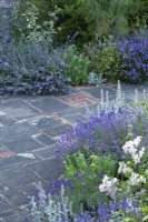 The paving is reused brick and stone found on site. Planting includes Lavenders 'Munstead' and 'Hidcote', Stachys byzantina and Rosa 'Ballerina'.