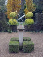 Armillary Sun Dial with Clipped Buxus - Box - hedging and topiary in the tea garden at - East Ruston Old Vicarage, Norfolk.