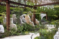 A metal framework and concrete panels amongst planting on the Samaritans' Listening Garden - designer Darren Hawkes - RHS Chelsea Flower Show 2023