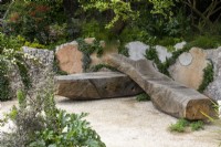 A sculptural wooden bench in the Samaritans' Listening Garden - designer Darren Hawkes - RHS Chelsea Flower Show 2023