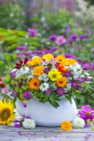 Summer bouquet with pot marigold, coneflowers, love in the mist, cosmos, red clover and achillea in a teapot.
