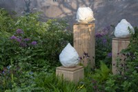 Ceramics by Gregory Tchalikian surrounded by planting on the RBC Brewin Dolphin Garden designed by Paul Hervey-Brookes - RHS Chelsea Flower Show 2023