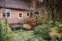 Balmoral Cottage, Kent in winter with bare branches and grasses in pots.