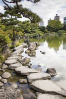 Stepping stones arranged at the lakes edge known as Iso-watari with view to city