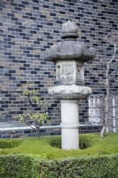 Stone lantern or Ishidoro with clipped shrub at entrance to the garden.