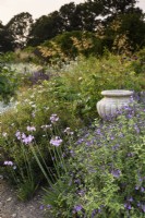 Stone urn in a border at Parham House Gardens in West Sussex in September