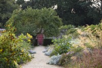 Path between silver borders in the walled garden at Parham House in September