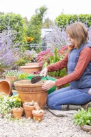 Woman filling container part way with compost