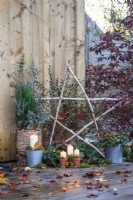 Light up Birch star, Candles, Cotoneaster, trug of Ivy, metal pot of Rosehips, wicker basket containing Juniper, Eucalyptus sprigs and Cornus twigs with moss placed around and leave scattered across the deck
