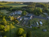 Aerial view of Mothecombe House in Devon, a Queen Ann building with extensive gardens set in rolling Devon countryside
