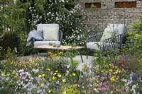 Seating area surrounded by wildlife friendly planting in The RSPCA Garden - Designer: Martyn Wilson - Sponsor: Project Giving Back -