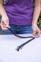 Woman taking three lengths of string and folding them in half
