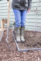 Woman stepping on compost to firm it in