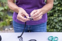 Woman pushing string through brace clip