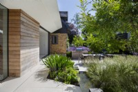 View across small water rill to modern garden and outdoor living area