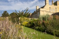 View across the herbaceous borders towards the period house at Bourton House Garden, Gloucestershire.