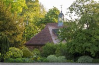 The old coach house is set amongst mature trees and shrubs, its belltower inspiration for the design of the central metal arbour in the walled garden.