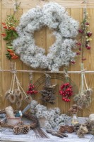 A wire wreath frame is wrapped in dried old man's beard, foraged from hedgerows and woodland along with teasels, rose hips, hawthorn berries, firethorn, fircones, cedar seed cones, dried yarrow and wild carrot flowerheads.