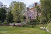 Pashley Manor, a fine sixteenth century building. Beds below the terrace are massed planted with tulips (right to left)white 'Mount Tacoma', 'Flaming Baltic', 'Dreamland', 'Barcelona', and 'Negrita'