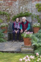Garden owners sitting on a bench in the walled garden.