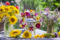 Wreath and bouquets of summer flowers including sunflowers, cosmos, persicaria, wild carrots, pot marigold and verbena.