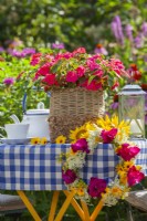 Impatiens in decorative pot and wreath of summer flowers including gladioli, sunflowers and wild carrots.
