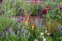 A copper rill with mixed perennial planting of Dahlia 'Sam Hopkins', Agastache rugosa 'Blue Fortune', Oenothera lindheimeri 'Whirling Butterflies', Kniphofia 'Papaya Popsicle'