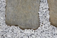 Detail of irregular stone slabs set into white gravel.