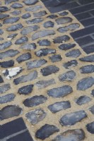 Detail of pathway of inlaid flint, edged with black bricks.